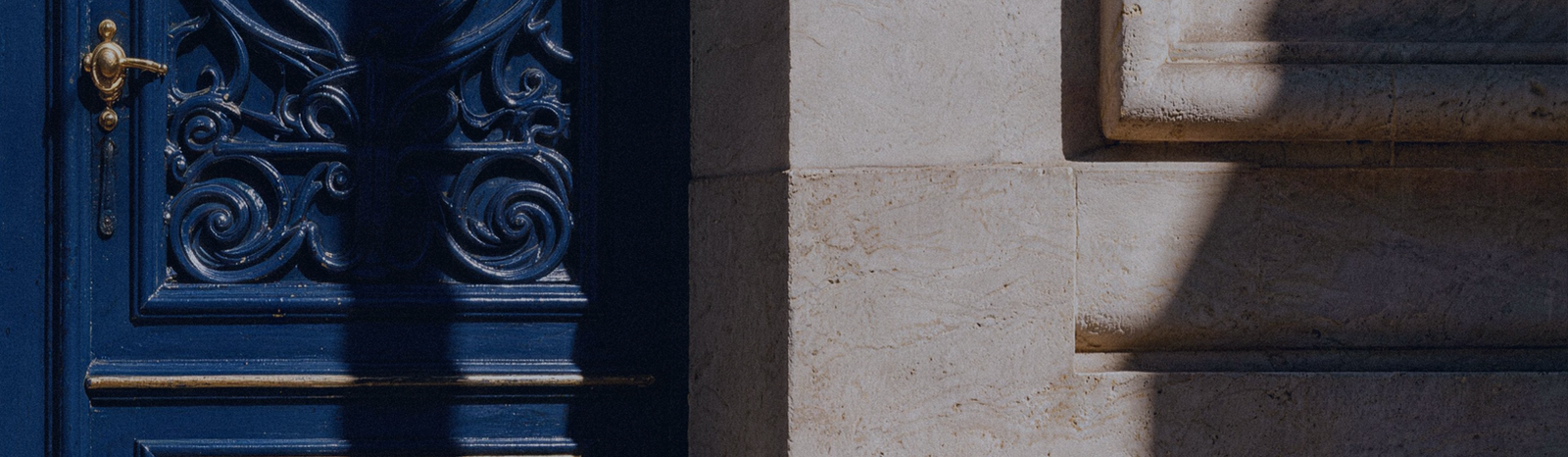 An ornate blue door beside a stone facade