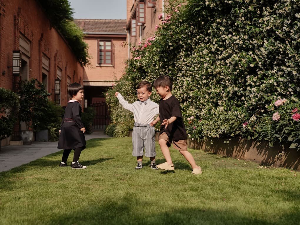 Three children playing together in a sunny garden